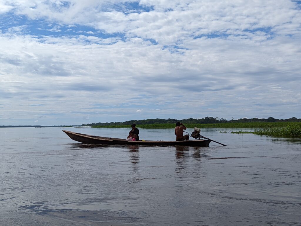 Famille qui pêche en pirogue sur l'Amazone